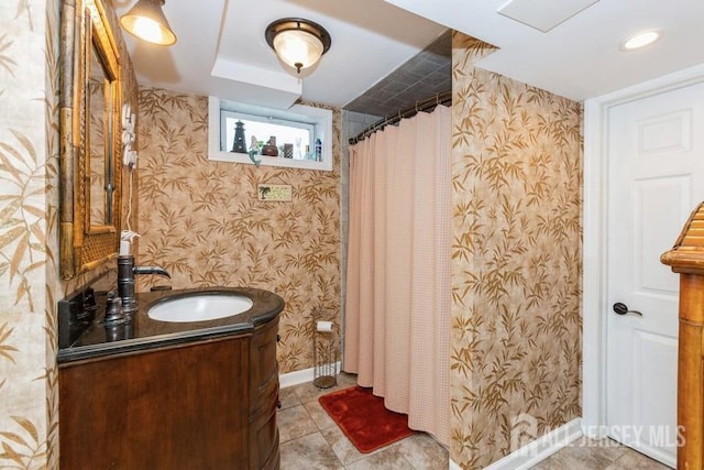 full bathroom with baseboards, wallpapered walls, tile patterned flooring, and vanity