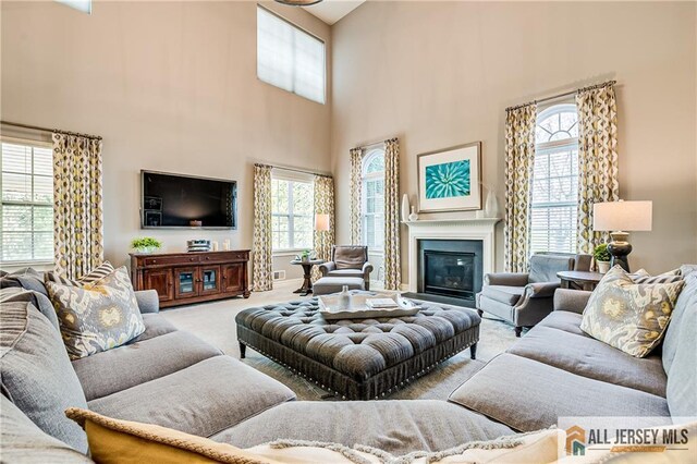 4 Van Gogh Ct, South Brunswick, NJ 08852 - carpeted living area featuring a towering ceiling, plenty of natural light, and a glass covered fireplace