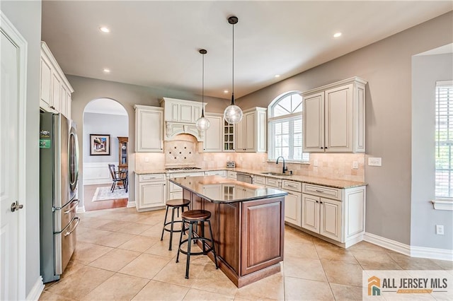 4 Van Gogh Ct, South Brunswick, NJ 08852 - kitchen with stainless steel appliances, arched walkways, a sink, light tile patterned floors, and backsplash