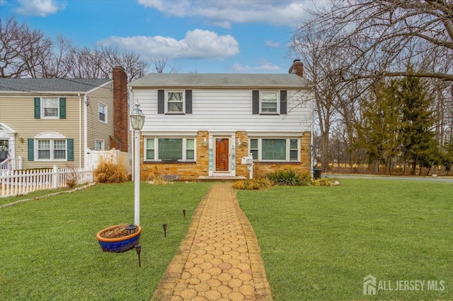 view of front of house featuring a front lawn, a chimney, and fence