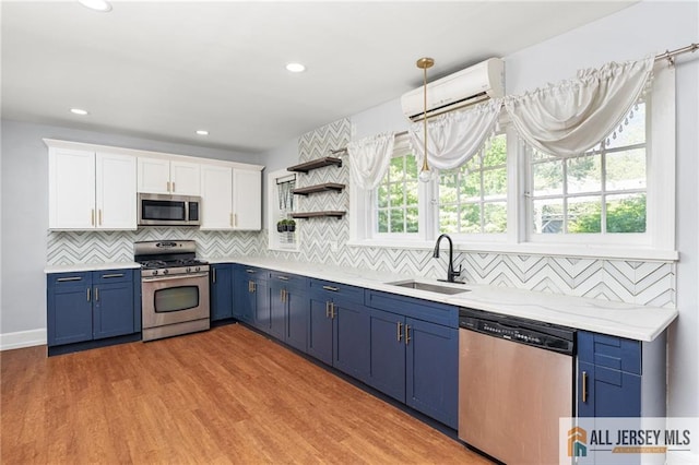 15 Kensington Ave, Trenton, NJ 08618 - kitchen featuring appliances with stainless steel finishes, blue cabinets, a wall mounted AC, white cabinets, and backsplash