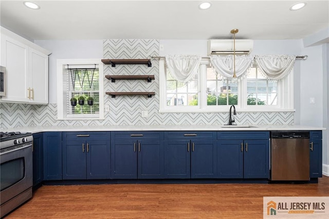 15 Kensington Ave, Trenton, NJ 08618 - kitchen with stainless steel appliances, blue cabinets, an AC wall unit, white cabinetry, and light countertops
