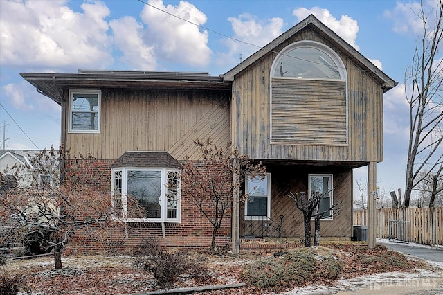 view of front of property with fence and brick siding