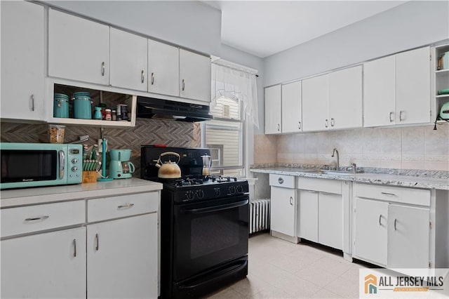 435 Ashley St, Perth Amboy, NJ 08861 - kitchen with black gas range oven, stainless steel microwave, under cabinet range hood, open shelves, and radiator
