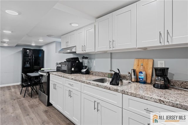 435 Ashley St, Perth Amboy, NJ 08861 - kitchen featuring stainless steel electric range, under cabinet range hood, light wood-style flooring, white cabinetry, and recessed lighting