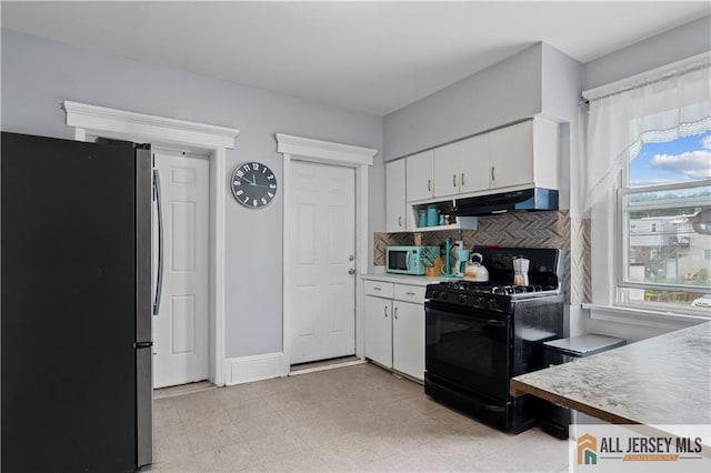 435 Ashley St, Perth Amboy, NJ 08861 - kitchen with freestanding refrigerator, black gas range, under cabinet range hood, white cabinets, and light countertops