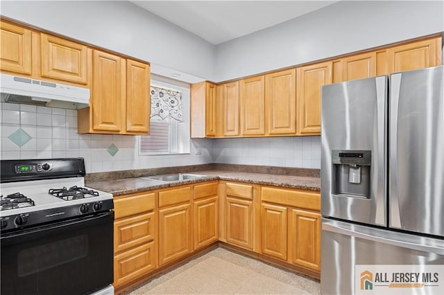 435 Ashley St, Perth Amboy, NJ 08861 - kitchen with stainless steel refrigerator with ice dispenser, black range with gas cooktop, under cabinet range hood, dark countertops, and tasteful backsplash