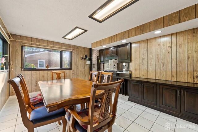 tiled dining area featuring wood walls