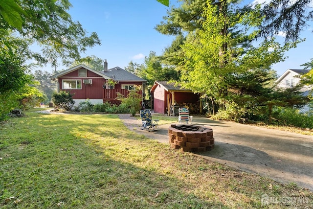 view of yard featuring a fire pit, a storage unit, and a wooden deck