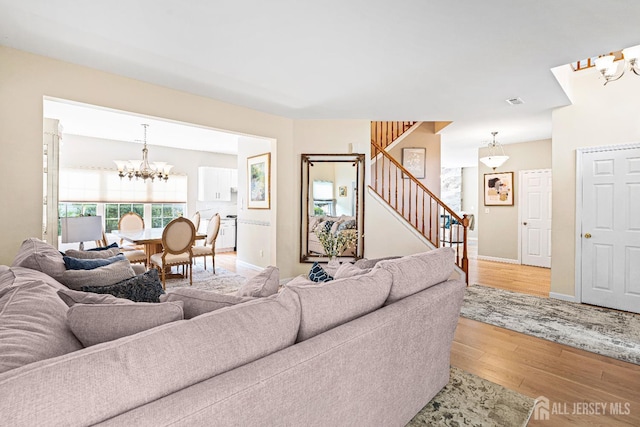 3 Devon Ct, Monroe, NJ 08831 - living room featuring a chandelier, stairs, wood finished floors, and baseboards