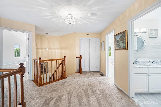 3 Devon Ct, Monroe, NJ 08831 - hallway with an upstairs landing, light carpet, a chandelier, and baseboards