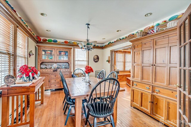 dining space with an inviting chandelier and light hardwood / wood-style floors