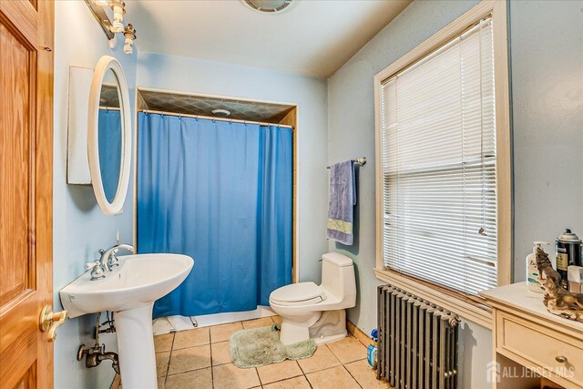 bathroom with radiator, tile patterned floors, toilet, and a shower with shower curtain