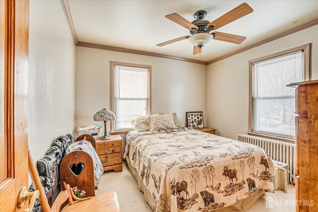 carpeted bedroom featuring multiple windows, ornamental molding, radiator heating unit, and ceiling fan