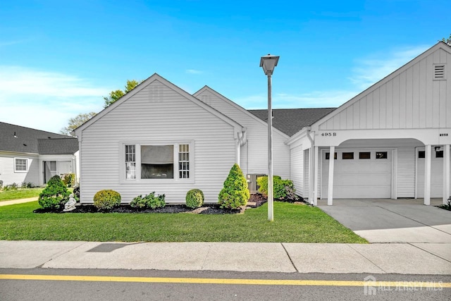 495 Newport Way Unit B, Monroe, NJ 08831 - view of front of property featuring board and batten siding, driveway, a front lawn, and a garage