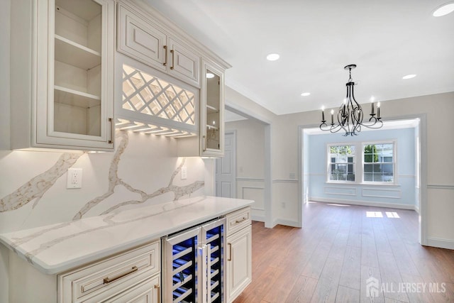 495 Newport Way Unit B, Monroe, NJ 08831 - bar with light wood-style flooring, a notable chandelier, a bar, decorative light fixtures, and beverage cooler