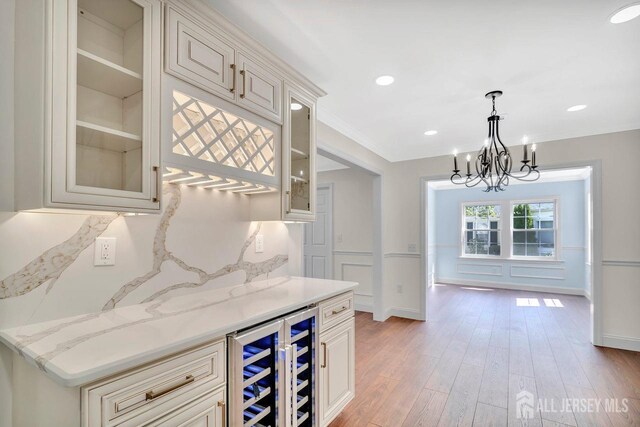 495 Newport Way Unit B, Monroe, NJ 08831 - kitchen with beverage cooler, a chandelier, glass insert cabinets, light wood-style floors, and hanging light fixtures