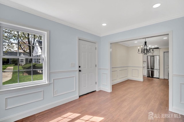 495 Newport Way Unit B, Monroe, NJ 08831 - entryway featuring a wainscoted wall, an inviting chandelier, ornamental molding, light wood-style floors, and a decorative wall