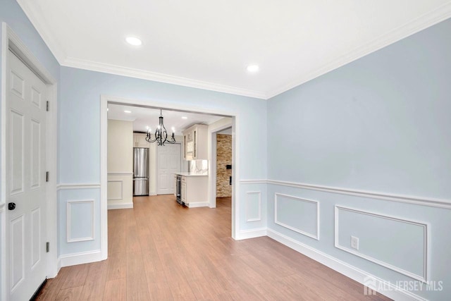 495 Newport Way Unit B, Monroe, NJ 08831 - interior space with light wood-style flooring, a chandelier, a wainscoted wall, and a decorative wall