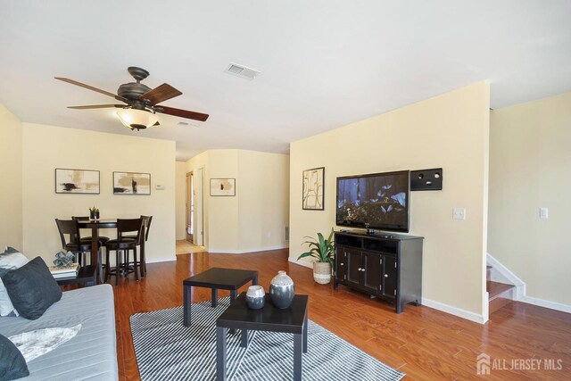 living room featuring hardwood / wood-style flooring and ceiling fan