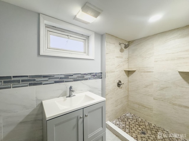 bathroom featuring vanity, tile walls, and tiled shower