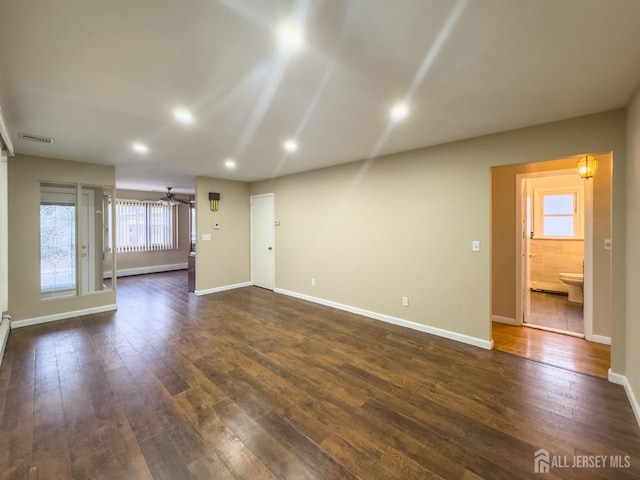 unfurnished living room featuring dark hardwood / wood-style floors and a baseboard radiator