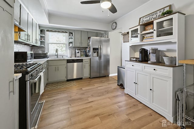 56 3rd Ave, Port Reading, NJ 07064 - kitchen with appliances with stainless steel finishes, open shelves, a ceiling fan, light wood-type flooring, and backsplash