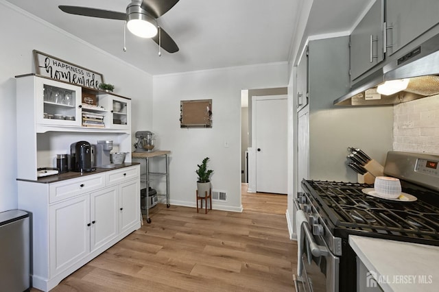 56 3rd Ave, Port Reading, NJ 07064 - kitchen featuring gas range, under cabinet range hood, light wood-style flooring, ornamental molding, and ceiling fan