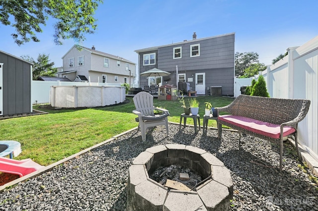 56 3rd Ave, Port Reading, NJ 07064 - back of house with a fire pit, a fenced backyard, and an outdoor pool