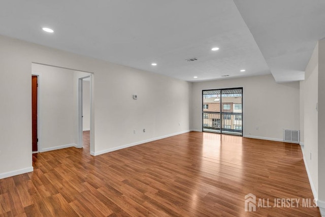 empty room featuring baseboards, visible vents, and light wood finished floors