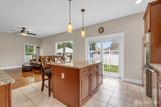 51 N Smith St, Avenel, NJ 07001 - kitchen with brown cabinetry, a breakfast bar, freestanding refrigerator, hanging light fixtures, and open floor plan