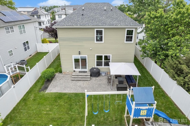 51 N Smith St, Avenel, NJ 07001 - back of house featuring a playground, a patio area, roof with shingles, and a fenced backyard