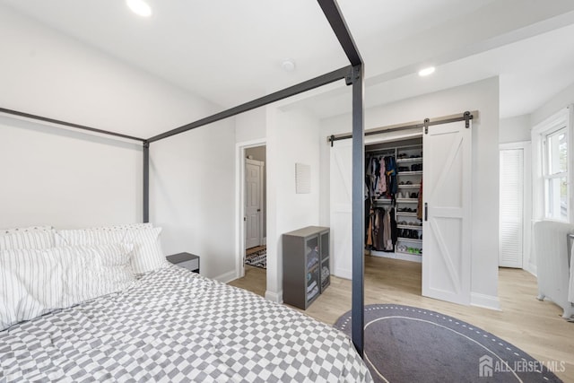 1402 Glenwood Dr, Piscataway, NJ 08854 - bedroom featuring a barn door, wood finished floors, a walk in closet, recessed lighting, and a closet