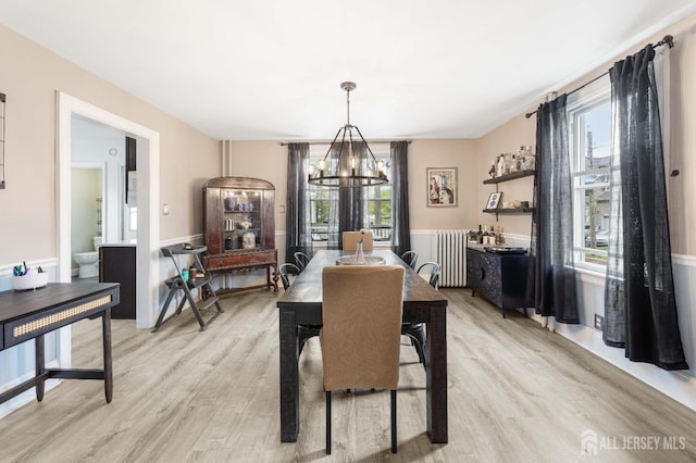 1402 Glenwood Dr, Piscataway, NJ 08854 - dining area with a chandelier, radiator heating unit, healthy amount of natural light, and light wood-style floors