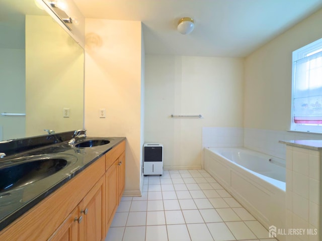 315 Birch Ct, New Brunswick, NJ 08901 - bathroom with heating unit, double vanity, a garden tub, tile patterned flooring, and baseboards