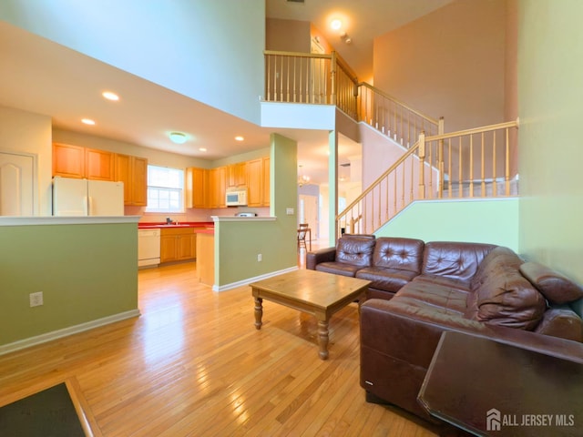 315 Birch Ct, New Brunswick, NJ 08901 - living area with light wood-type flooring, stairs, a high ceiling, recessed lighting, and baseboards
