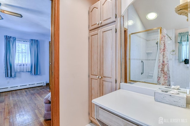 79 S Hill Rd, Colonia, NJ 07067 - bathroom with a shower with shower door, a baseboard radiator, a ceiling fan, hardwood / wood-style flooring, and recessed lighting