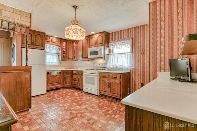 79 S Hill Rd, Colonia, NJ 07067 - kitchen with white appliances, wallpapered walls, brown cabinets, a sink, and a textured ceiling