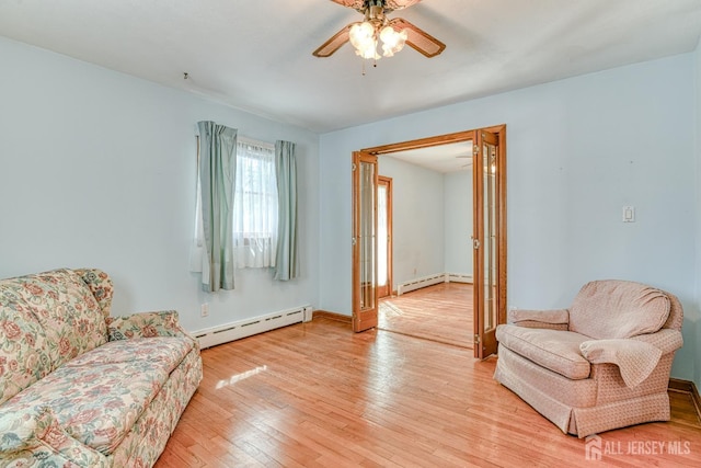 79 S Hill Rd, Colonia, NJ 07067 - living area with a baseboard heating unit, light wood finished floors, a ceiling fan, and baseboards