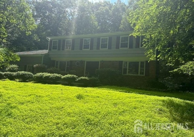 colonial home featuring a front lawn