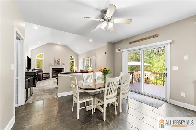 dining room featuring dark colored carpet, ceiling fan, and lofted ceiling