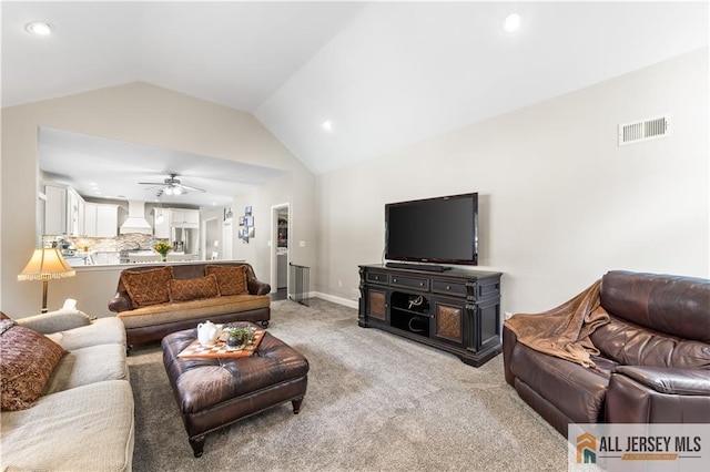 carpeted living room with ceiling fan and lofted ceiling