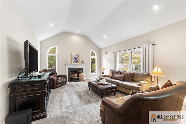 carpeted living room with plenty of natural light and lofted ceiling