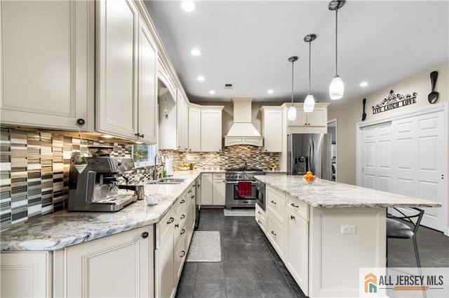 kitchen with pendant lighting, custom exhaust hood, backsplash, appliances with stainless steel finishes, and a kitchen island