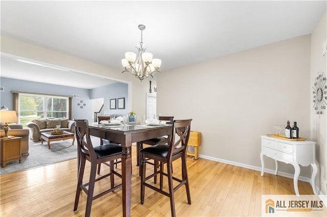 dining space featuring a chandelier and light wood-type flooring