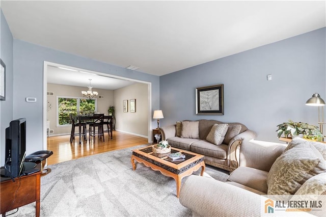 living room with a notable chandelier and wood-type flooring