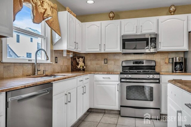 6 Muravski Ct, South River, NJ 08882 - kitchen featuring stainless steel appliances, white cabinets, light tile patterned flooring, backsplash, and recessed lighting