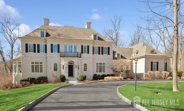 56 Cradle Rock Rd, Princeton, NJ 08540 - colonial-style house with a balcony, driveway, stucco siding, a chimney, and a front yard