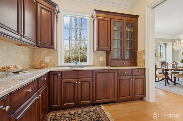56 Cradle Rock Rd, Princeton, NJ 08540 - kitchen featuring a chandelier, light wood finished floors, light stone counters, glass insert cabinets, and ornamental molding