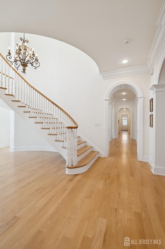 56 Cradle Rock Rd, Princeton, NJ 08540 - entryway featuring stairway, arched walkways, crown molding, light wood finished floors, and a chandelier